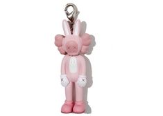 a pink keychain with a bunny on it's back and ears hanging from the side