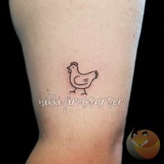 a small chicken tattoo on the back of a woman's leg, with words underneath it