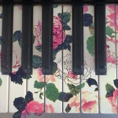 an old piano with flowers painted on it's sides and the keys are black