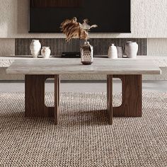 a table with vases on it in front of a wall mounted flat screen tv