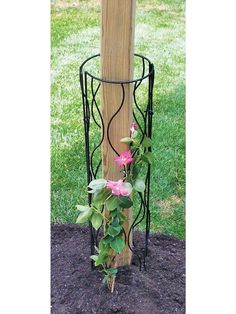 a wooden pole with flowers growing out of it next to a planter in the ground