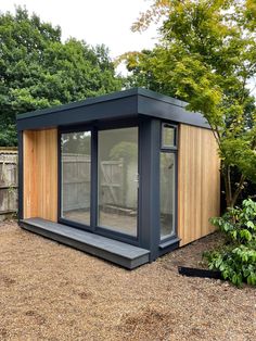 a small wooden building sitting in the middle of a yard