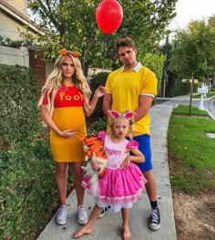 a man, woman and child are dressed up as winnie the pooh and tigger