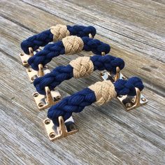 three blue and tan rope bracelets with metal clasps on wooden background, closeup