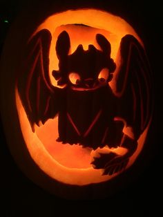 a carved pumpkin with an image of a demon on it