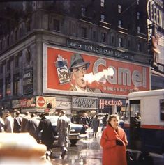 an old photo of people walking down the street in front of a gamel store