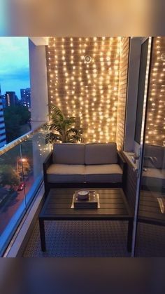 a living room with lights on the wall and a couch in front of a window