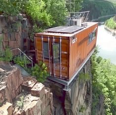 an orange shipping container sitting on top of a cliff