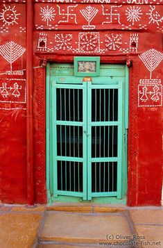 a red building with green doors and writing on it