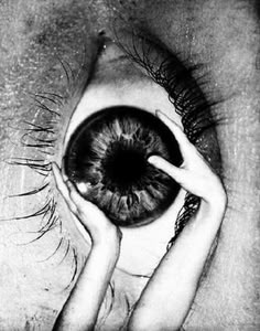 a black and white photo of a person holding an eyeball in their right hand