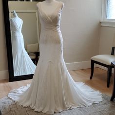 a wedding dress on display in front of a mirror