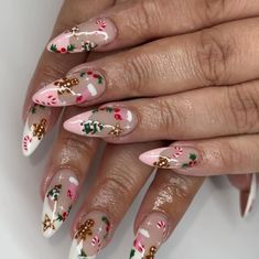 These almond-shaped nails showcase gingerbread men, holly, and candy canes for a cozy Christmas-inspired design. The soft pink and white base adds a subtle background for the holiday elements. This simple yet festive look is perfect for a winter manicure with a playful touch. Winter Nails Gingerbread, Ginger Bread Nails Pink, Christmas Nails Almond Gingerbread, Christmas Manicure Nails, Candy Cane And Gingerbread Nails, White Base Christmas Nails, Christmas Gingerbread Man Nails, Holiday Nails Gingerbread, Brown Gingerbread Nails