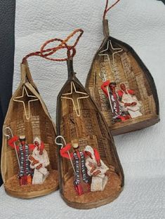 three pieces of wood that have been decorated with pictures on them and hanging from strings