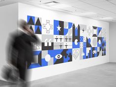 a person walking past a large blue and white wall