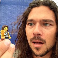 a man with long hair holding a lego figure