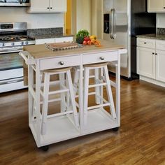 a kitchen with two stools on the island in front of the stove and refrigerator