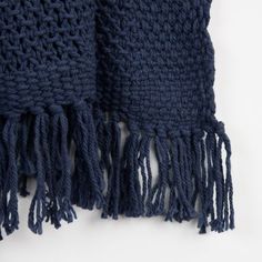 a blue scarf with fringes laying on top of it