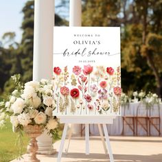 a welcome sign with flowers on it in front of an outdoor ceremony venue for a bride and groom