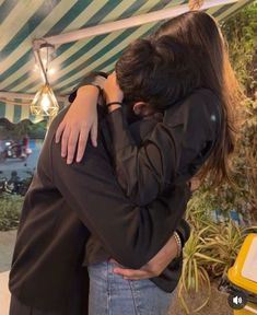 two people embracing each other under a tent