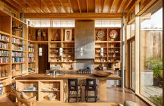 a kitchen with lots of wooden shelves filled with books