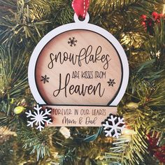 a wooden ornament hanging on a christmas tree with snowflakes around it