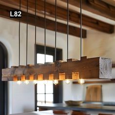 a chandelier made out of wooden planks hanging from the ceiling in a dining room