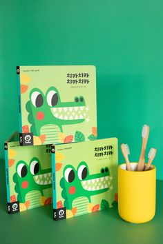 three children's books with toothbrushes in front of them on a green background