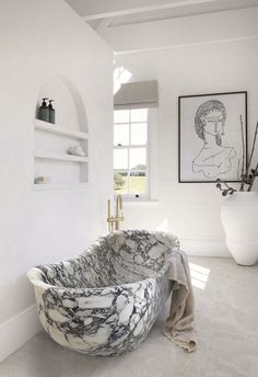 a bathtub sitting in the middle of a bathroom next to a window