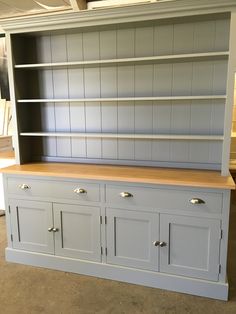 a white painted bookcase with drawers and cupboards