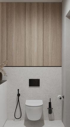 a white toilet sitting in a bathroom next to a wooden paneled wall with a black faucet