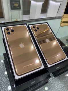 two gold iphones are sitting on display in a case at an apple store,