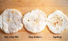 three tortillas sitting on top of a wooden cutting board next to each other