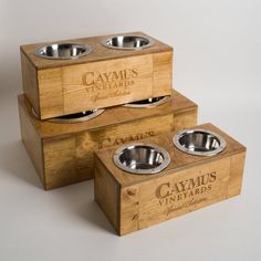 two wooden boxes with metal bowls in them