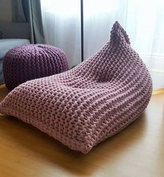 two knitted bean bags sitting on top of a wooden floor next to a window