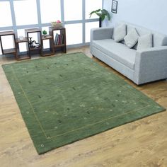 a living room filled with furniture and a green rug on top of a hard wood floor