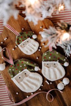 three decorated christmas ornaments sitting on top of a wooden board