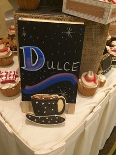 a table topped with cupcakes and cakes next to a sign that says dulce