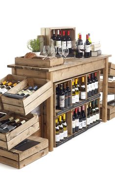 an assortment of wine bottles and glasses are on display in a wooden crate with drawers