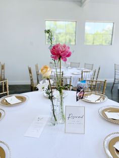 the table is set with flowers and place cards for guests to sit down at it