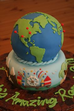 a cake that is sitting on top of a table with the world in it's center