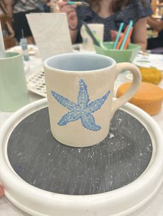 a coffee cup sitting on top of a white plate