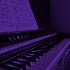 an old piano with sheet music in the background and yamaha written on it's side