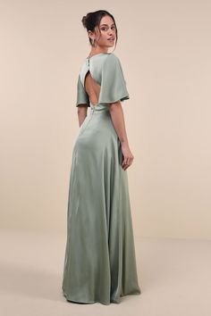 the back of a woman wearing a green dress with open shoulders and an open back