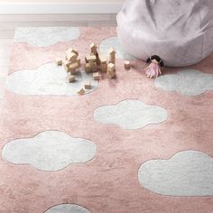 a child's play area with pink and gray rugs, toys and stuffed animals