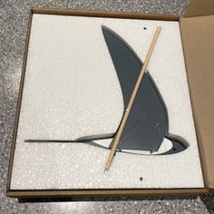 an open box with a knife in it on the ground next to a cardboard box