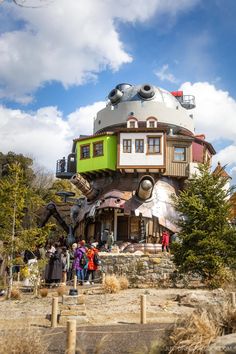 people are standing in front of a house with a large dome on it's roof