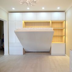 an empty room with white cabinets and a large rectangular shaped object in the center that appears to be floating