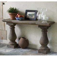 a table with some fruit on top of it next to a potted plant and vase