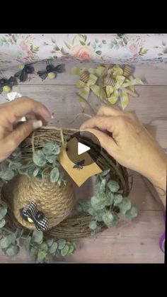 two hands are decorating a wreath with twine