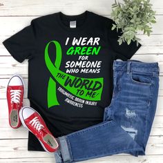 "* All shirts are unisex. * Product measurements may vary by up to 2 inches. * All Designs are originally made by myself or my team.  Brain Injury Awareness shirt with the quote \"Traumatic Brain Injury Awareness\" is a fun gift for men and women!  To see more designs of your topic Brain Injury Awareness you can search & find them in my store:   https://www.etsy.com/shop/Retailorie  You find there also an announcement if the shipping & production times change :) I wear green,support squad shirt,brain injury shirt,brain injury tshirt,tbi awareness,green ribbon,head injury shirt,tbi shirt,tbi gift,brain surgery shirt,trauma brain,brain surgery gift," Black Graphic Print T-shirt For Awareness Events, Traumatic Brain Injuries Awareness Month, Neuro Nurse Shirt, Awareness Tshirts, Rare Disease Awareness Shirts, Surgery Gift, Band Shirt, Ribbon Shirt, Squad Shirt